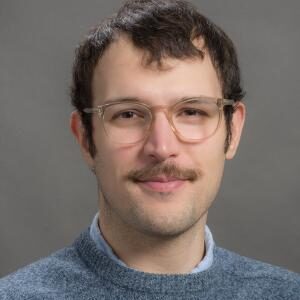 Formal headshot of faculty member Alex Meeske.