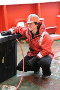 Professional full body photo of faculty member Brook Nunn on a ship.