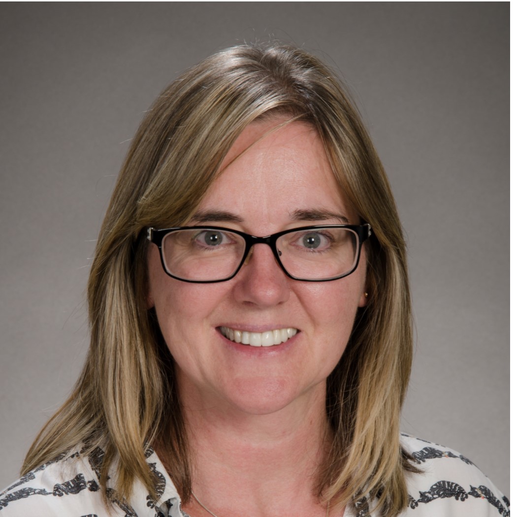 Professional headshot of MCB staff member Denise Barnes with grey background.