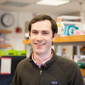 Formal headshot of faculty member Neil King in lab.