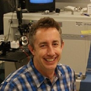 Formal headshot of faculty member Michael MacCoss in lab.