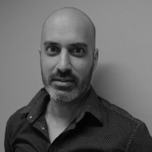Formal black and white headshot of faculty member Ajay Dhaka.