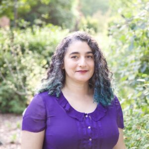 Formal headshot of faculty member Jennifer Nemhauser in garden.