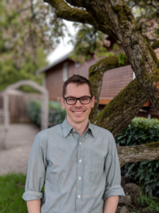 Headshot of faculty member Cole Trapnell standing in front of a tree.